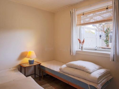 JægersprisHoliday home Jægerspris XLI的客房设有两张床和一个带长凳的窗户。