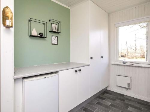 蒂霍尔姆Holiday Home Fyrrevej的一间带白色橱柜和窗户的浴室
