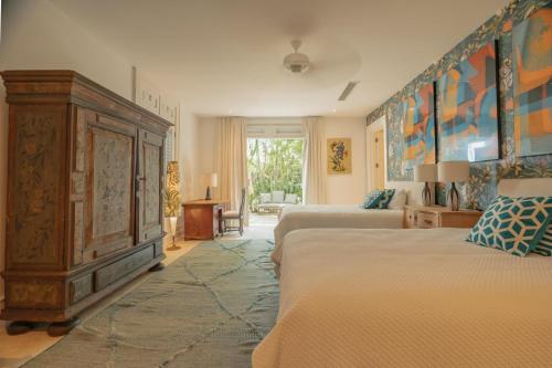 蓬塔卡纳Luxurious fully-staffed villa with amazing view in exclusive golf & beach resort的一间带两张床和大型木制橱柜的卧室