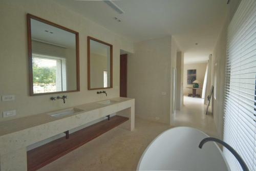 蓬塔卡纳Unique golf front villa with modern design in exclusive beach resort的带浴缸、水槽和镜子的浴室