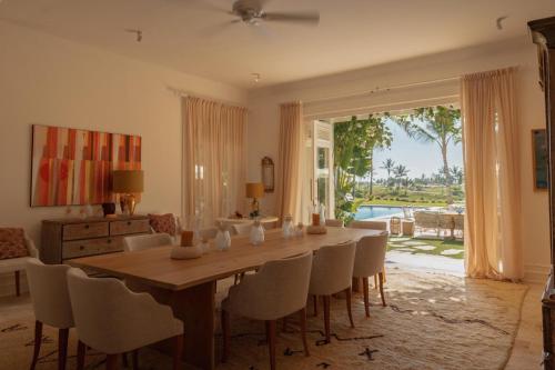 蓬塔卡纳Unique lake-front 10-bedroom mansion in most luxurious resort of the caribbean的一间带木桌和椅子的用餐室