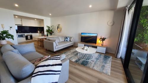 黄金海岸Luxury Oceanview Apartment on Lvl 24的客厅配有沙发和桌子