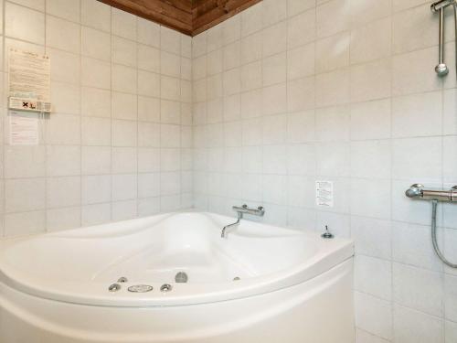 SindrupHoliday Home Fjordternevej的白色瓷砖浴室内的白色浴缸