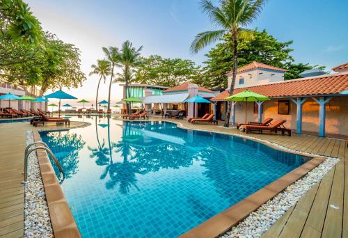 查汶Baan Samui Resort - SHA Extra Plus的度假村的游泳池,配有椅子和遮阳伞