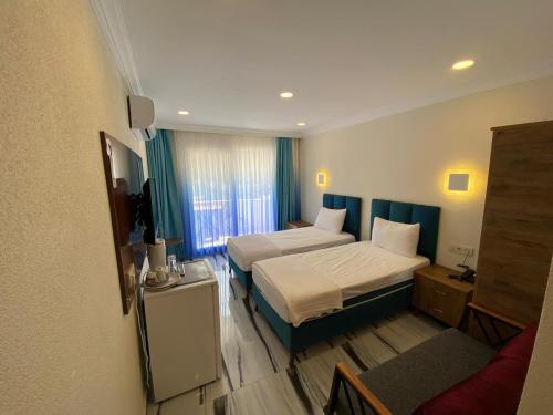 迪迪姆Garden Butik & Apart Hotel Akbük的酒店客房,设有两张床和一张沙发