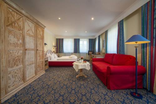 福森阿克提夫施威格尔酒店的一间带红色沙发的客厅和一间卧室