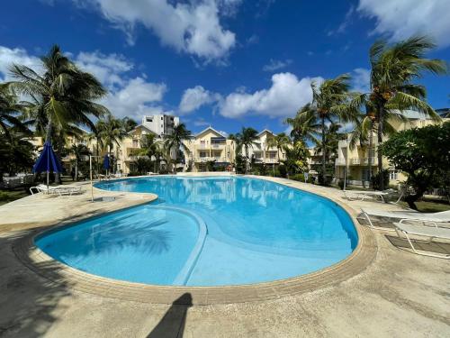 弗利康弗拉克Le Tamier - Amazing holidays的一座棕榈树大型游泳池,