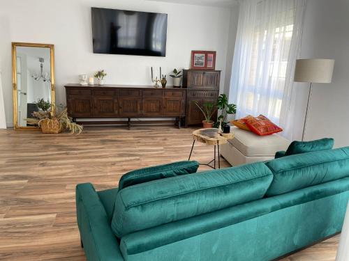 圣卡洛斯拉腊皮塔Apartamento Dakota的客厅配有绿色沙发和电视