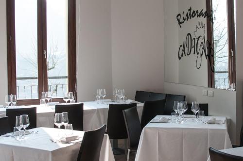 萨索马可尼Hotel Ca' di Gali的用餐室配有桌椅和酒杯
