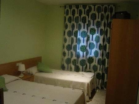 马德里埃米利奥巴拉哈斯旅馆的客房设有两张床和一个带窗帘的窗户。