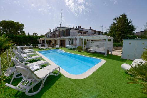 卡萨诺德莱穆尔杰In Villa Cielo的后院设有游泳池、椅子和房屋