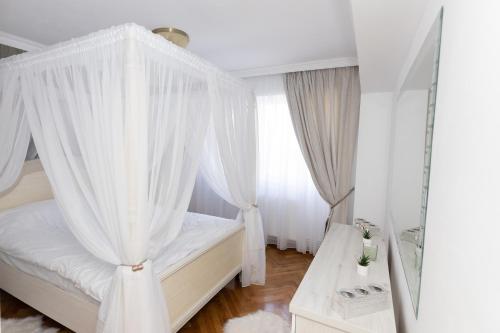 加拉茨ALPASIO RENTALS的卧室配有带白色窗帘的天蓬床