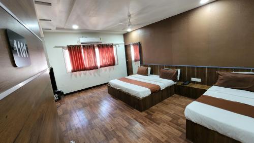 艾哈迈达巴德Hotel Nova Prime的酒店客房设有两张床和窗户。