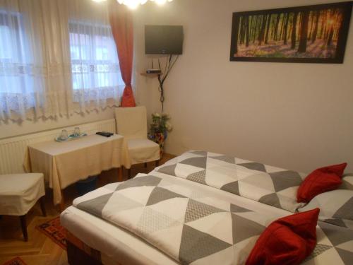 布达佩斯柯索柏金链花旅馆的一间卧室配有一张床、一张桌子和一个窗户。