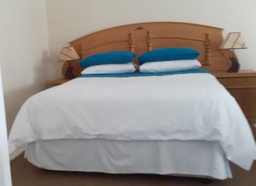 姆巴巴内Liz' Cottage的一张带蓝色和白色枕头的床