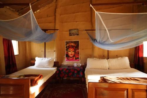 BhurkīāForest Hideaway Resort Pvt Ltd的一间卧室配有两张带蚊帐的床。