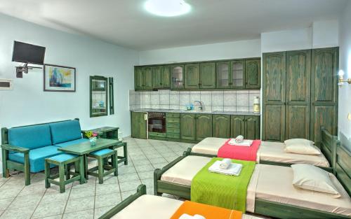 卡利斯托斯Hotel Zeus的带三张床和一张桌子的房间以及厨房