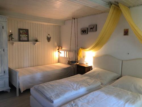 KrummenauRomantikmühle Heartlandranch的卧室内的两张床,配有两盏灯