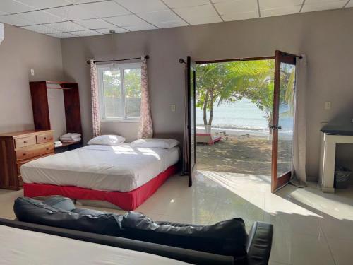 Puerto ArmuellesBig Daddy's Beach Club & Hotel的一间卧室设有两张床和滑动玻璃门