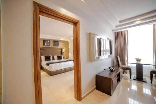 拉各斯Victoria Crown Plaza Hotel的一张大镜子,位于酒店带床的房间里