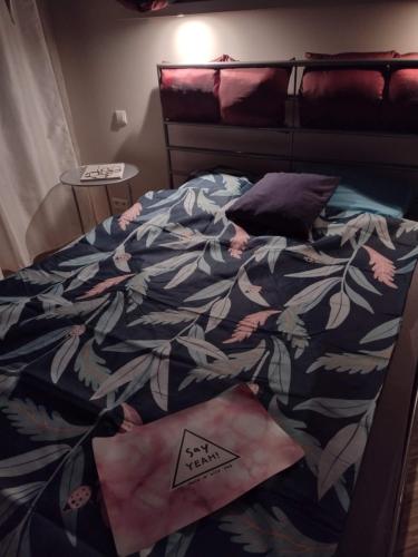 华沙TOtuTOtam的一间卧室配有一张带花卉棉被的床