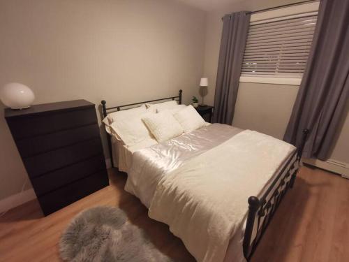 伦敦Modern 1 bedroom apartment in Wortley Village的一间卧室配有一张床、一个梳妆台和一扇窗户。