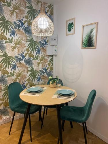 勒阿弗尔Vivez La forêt - Port de plaisance - Plage的一间带木桌和绿色椅子的用餐室