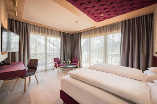 洛伊塔施Hotel Kristall - Adults only的酒店客房配有两张床和一张书桌