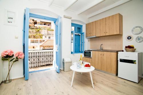 卡利诺岛spongkalyA apartment II的厨房配有白色桌子和白色冰箱。