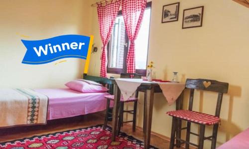 巴伊纳巴什塔Putnicka kuca kod Dragane的卧室配有一张床和一张桌子及椅子