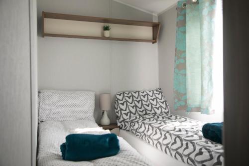 浦耳51 Lytchett Bay View, 3 bed, Rockley Park Poole的小房间设有两张床和窗户