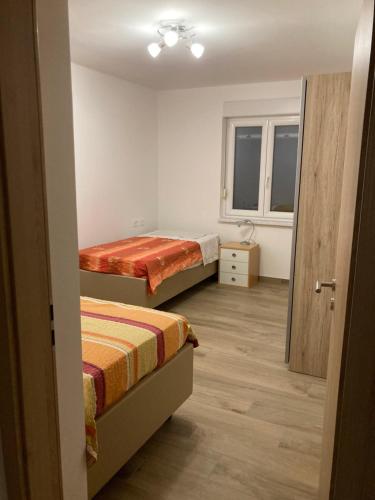 ČrničeFirst Vrtovin Apartment的小房间设有两张床和窗户