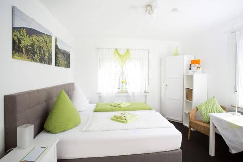 维宁根Hotel Emmerich的白色客房 - 带绿色枕头的床