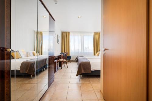 雷克雅未克Hotel Ísland - Comfort的酒店客房,设有两张床和镜子