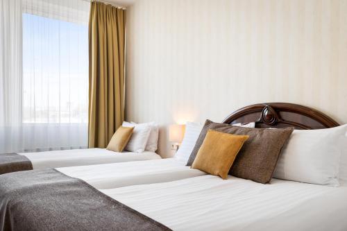 雷克雅未克Hotel Ísland - Comfort的酒店客房设有两张床和窗户。