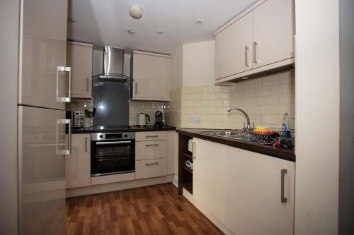 索尔兹伯里索尔兹伯里奢华公寓的厨房配有白色橱柜和不锈钢用具