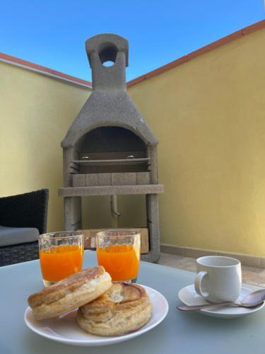 伊格莱西亚斯La Casetta L&L的一张桌子,上面放着一盘面包和两杯橙汁