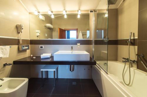 Fiesso dʼArtico茱莉艾塔玛别墅酒店的一间带水槽、浴缸和镜子的浴室