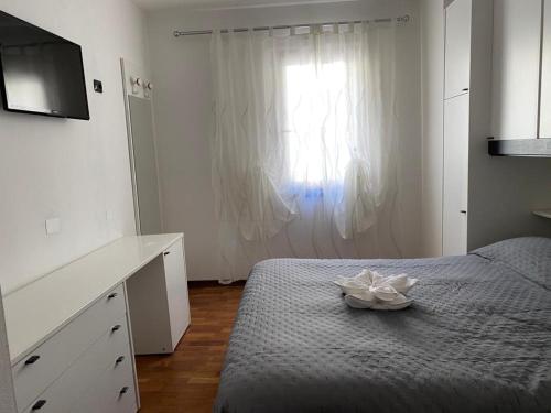 莫利纳迪莱德罗Appartamento Aurelia的一间卧室配有带梳妆台和窗户的床。