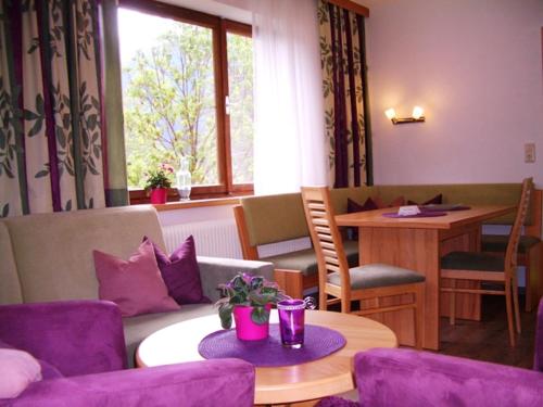 HäselgehrHaus Alpina的客厅配有紫色椅子和桌子