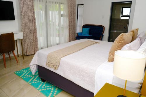 Mabele-a-podiGetty's Bed and Breakfast的一间卧室配有一张床和一张蓝色椅子