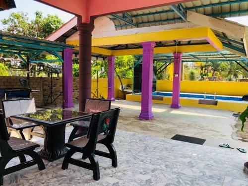 巴西富地Homestay TokAbah的一个带桌椅的庭院和一个游泳池
