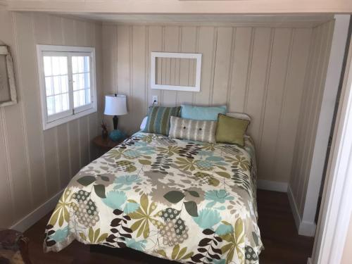 奥沙克湖Lakeshore Fishing Cabin #3, Ramp, dock, fire pit的一间卧室配有一张带花卉棉被的床