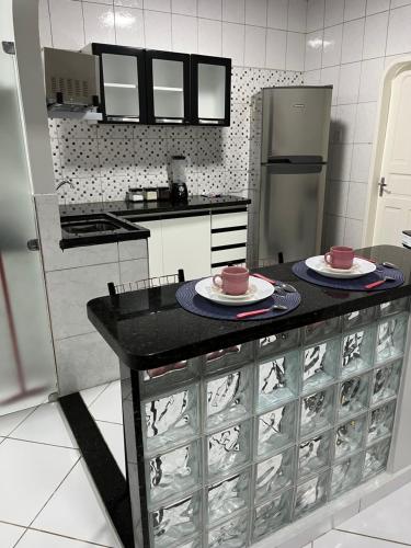 博阿维斯塔Apartamento em Boa Vista的厨房配有带2个盘子的柜台和冰箱