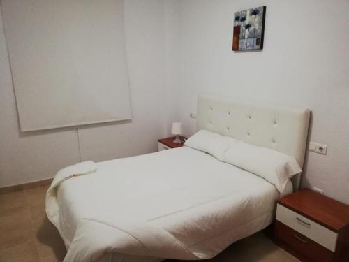 桑卢卡尔-德巴拉梅达apartamento princesa Leticia的卧室配有一张白色的大床和一张桌子