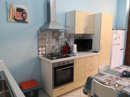 特拉佩托Short Lets Vacanze "Massimo"的一间带炉灶的厨房 桌子旁的顶部烤箱