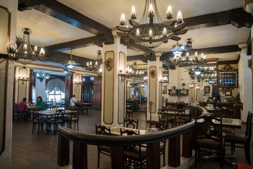 维多利亚城Hotel Sierra Gorda的餐厅设有桌椅和吊灯。