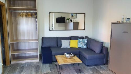 圣玛丽亚港Apartamento Marina el Puerto的客厅配有一张蓝色的沙发,配有一张桌子