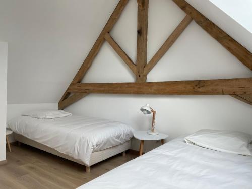 埃斯卡勒GÎTE 2 Ferme de la Haute Escalles的配有木天花板的客房设有两张床。