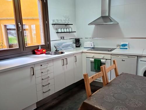 阿拉力兹Apartamento CASCO HISTÓRICO的厨房配有白色橱柜、水槽和桌子
